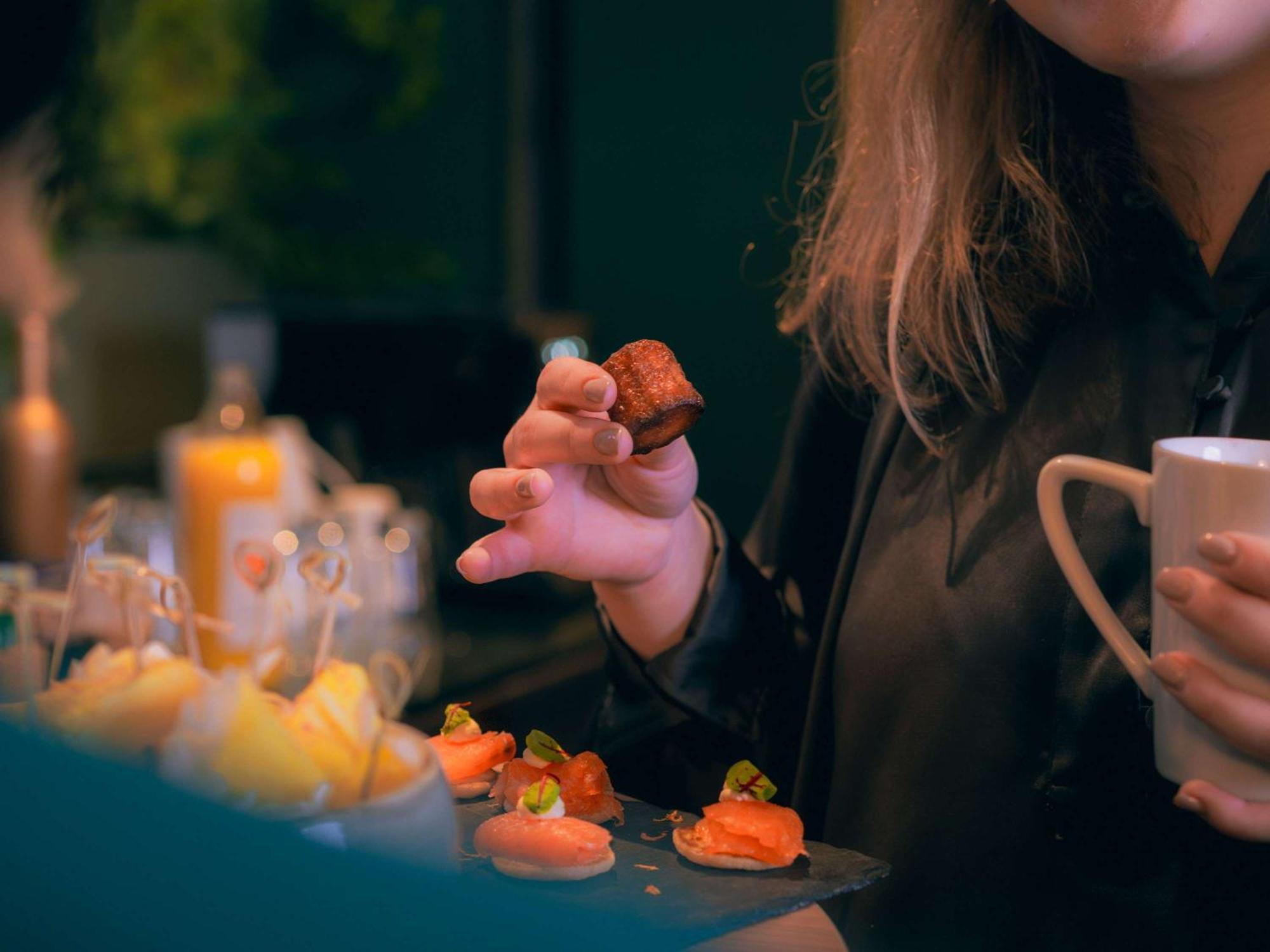 Nest Hotel Paris La Defense - Mgallery Collection פוטו מראה חיצוני תמונה A woman holding a piece of sushi